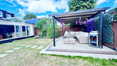 a backyard with a pergola with a couch and a table at 5 Bruce Avenue in Shepperton