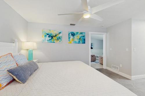 ein weißes Schlafzimmer mit einem Bett und einem Deckenventilator in der Unterkunft Snow We're Not in Englewood