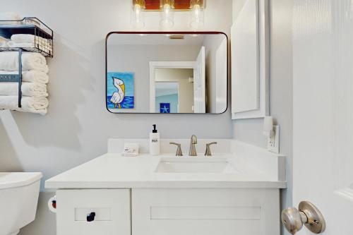 ein weißes Badezimmer mit Waschbecken und Spiegel in der Unterkunft Snow We're Not in Englewood