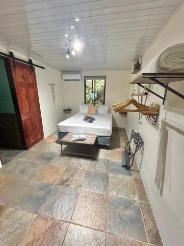 a bedroom with a bed and a table in a room at Boutique Rooms River Front at La Junta in Dominical