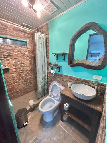 a bathroom with a sink and a toilet and a mirror at Boutique Rooms River Front at La Junta in Dominical