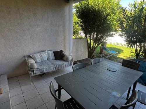 a table and chairs and a couch on a patio at Mini villa Corse du sud Residence U Re D Alzetu in Lecci
