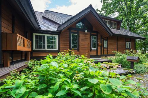 a house with a garden in front of it at Ringo Lodge Hakuba in Hakuba