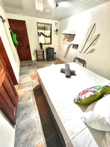 a bedroom with a white bed and a table at Boutique Rooms River Front at La Junta in Dominical
