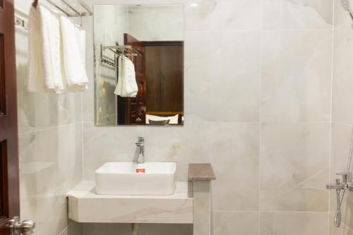 a white bathroom with a sink and a mirror at Atana Saigon Boutique Hotel II in Ho Chi Minh City