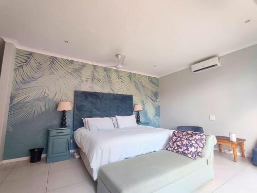 a bedroom with a white bed and a couch at Harris Estate Country Home in Ballito