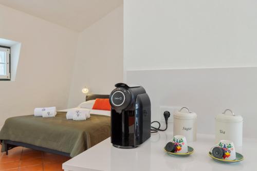 a coffee maker sitting on a counter with two cups at Sapalinho Retreat - By Y Concept in Setúbal