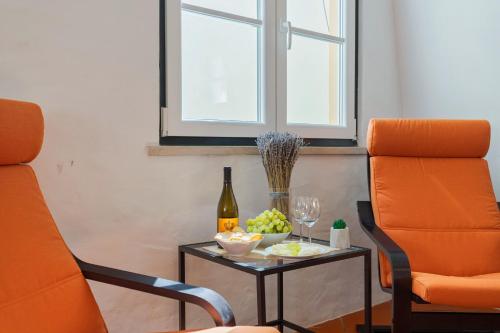 an orange chair and a table with a bottle of wine at Sapalinho Retreat - By Y Concept in Setúbal