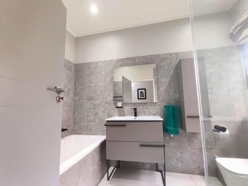 a bathroom with a sink and a tub and a toilet at Harris Estate Country Home in Ballito
