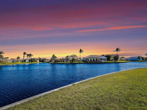 フォートマイヤーズにあるRelax at Lake Breeze 4BR Fort Myers Getawayのヤシの木と背景の家がある湖