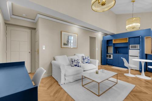 a living room with a white couch and a table at Les Relais du Capitole - Appartements d'hôtes in Toulouse