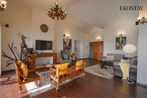 ein Wohnzimmer voller Möbel und einem Kronleuchter in der Unterkunft EKOSTAY - Skyfall Cloud 9 Villa in Udagamandalam