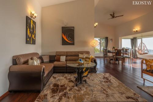 a living room with a couch and a table at EKOSTAY - Skyfall Cloud 9 Villa in Ooty