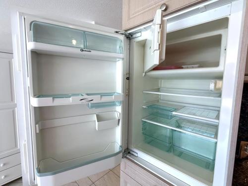 Un refrigerador vacío con la puerta abierta en una cocina. en Château 15, en Leukerbad