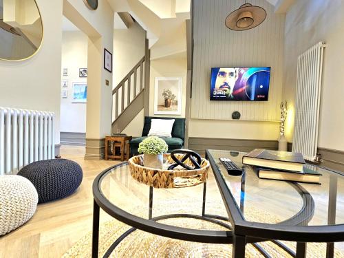 a living room with a glass table and a couch at Newly Renovated Gem - Free Parking & Modern Comfort in Glasgow