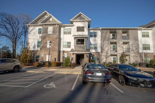 ein großes Gebäude mit auf einem Parkplatz abgestellten Autos in der Unterkunft Beautiful Apartment in Concord with swimming pool and Gymn in Charlotte