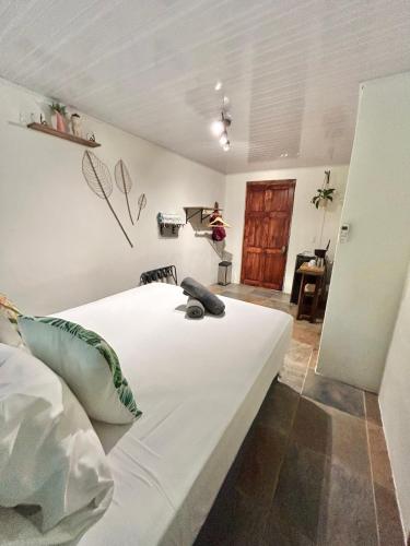 a bedroom with a large white bed in a room at Boutique Rooms River Front at La Junta in Dominical