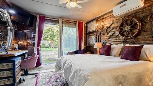 a bedroom with a bed and a wooden wall at Port Royale Beach Cottage in Shelly Beach