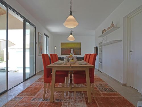 comedor con mesa de madera y sillas rojas en Villa in Malaucène with Heated Pool, en Malaucène