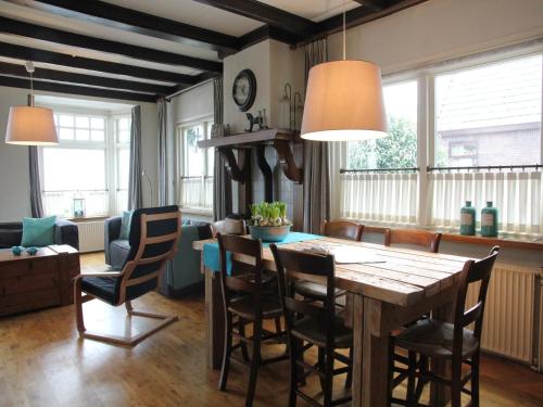 Una sala de estar con una mesa y sillas de madera. en Holiday Home in Nijeberkoop near Nature, en Nijeberkoop