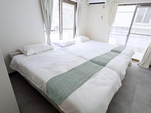 a large bed in a room with a large window at 'Yoyogi House' 10min Walk Shinjuku&Shibuya in Tokyo