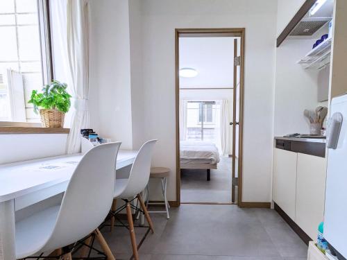 a dining room with a white table and chairs at 'Yoyogi House' 10min Walk Shinjuku&Shibuya in Tokyo