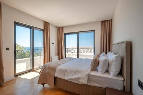 a bedroom with a bed with views of the ocean at Luxury Villa - New Building with pool and Fantastic Side Sea View in Budva