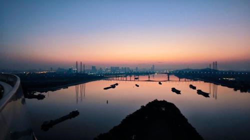 a group of ducks swimming in a river at sunset at Vignette Collection The Xanadu Guangzhou, an IHG Hotel in Guangzhou
