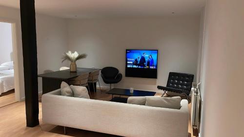 a living room with a couch and a table and a television at Maison Nord, 6 min from Airport & Sleep 5 in Copenhagen