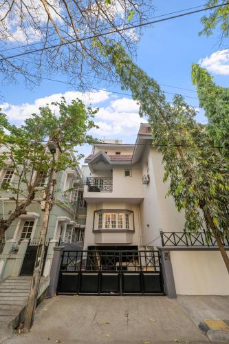 a large white building with a staircase in front of it at Urban Escape 4BHK Luxury Villa & Sunflower Skyline 2BHK Penthouse By Spacez in Bangalore