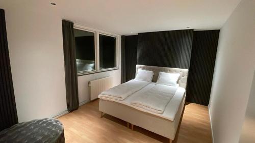 a bedroom with a white bed and a window at Maison Nord, 6 min from Airport & Sleep 5 in Copenhagen