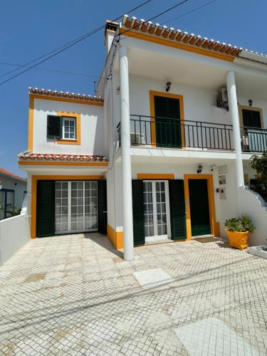 a large white house with a courtyard at Refúgio do Mira in Vila Nova de Milfontes