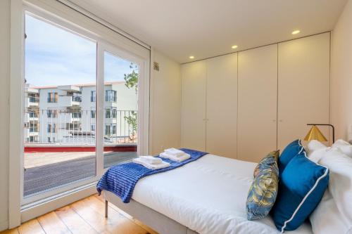 ポルトにあるMagnolia 5 Luxury with AC Metro Downtown Portoのベッドと大きな窓のある寝室