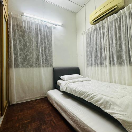 a bedroom with two beds and a window at RapaatVip Homestay in Ipoh