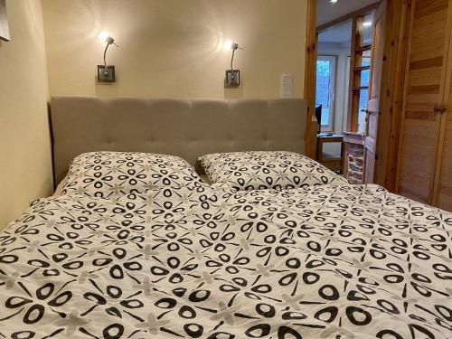 a bed with a black and white comforter and two pillows at Retreat with Private Garden in Güntersberge