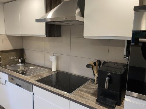 a kitchen with white cabinets and a sink and a stove at Retreat with Private Garden in Güntersberge