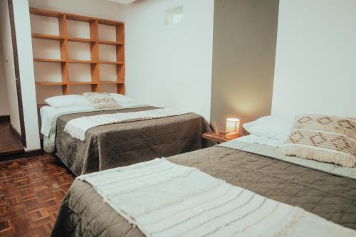a bedroom with two beds and a book shelf at Central Hostel Metro10 in Guatemala