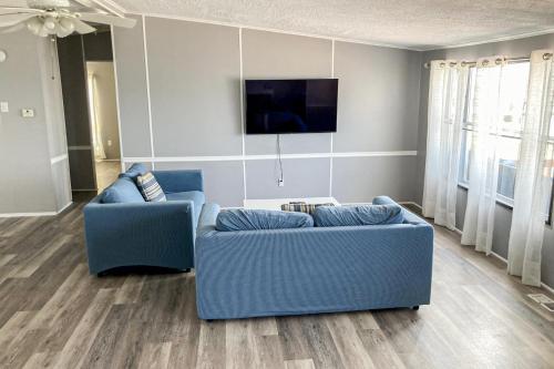 a living room with a blue couch and a tv at Reel Paradise in Atlantic Beach