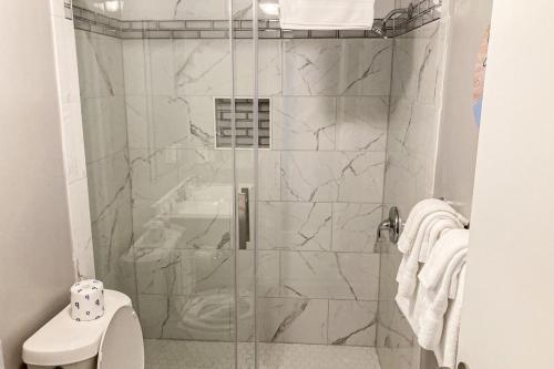 a shower with a glass door in a bathroom at Reel Paradise in Atlantic Beach