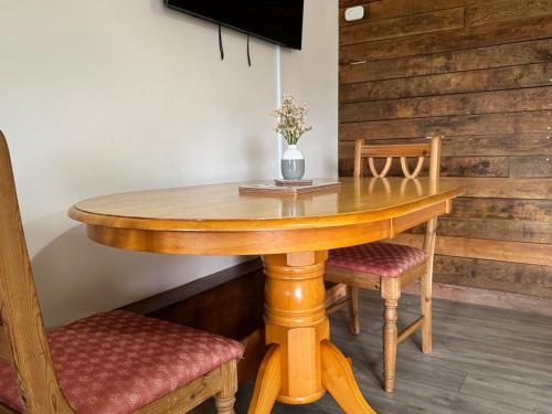 a wooden table with two chairs and a vase on it at The Riley Stable in Waterlooville