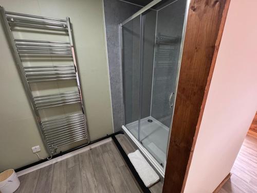 a shower with a glass door in a bathroom at The Riley Stable in Waterlooville