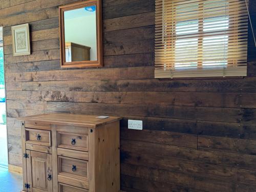 a room with a mirror and a wooden wall at The Riley Stable in Waterlooville