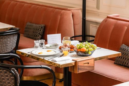 una mesa con un bol de fruta en ella en Hôtel Les Lumières - Relais & Châteaux, en Versalles