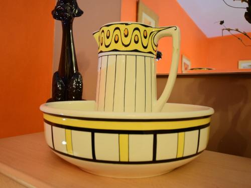 a yellow and white bowl with a tea pot in it at Celtic Charm in Berismenil in Bérisménil