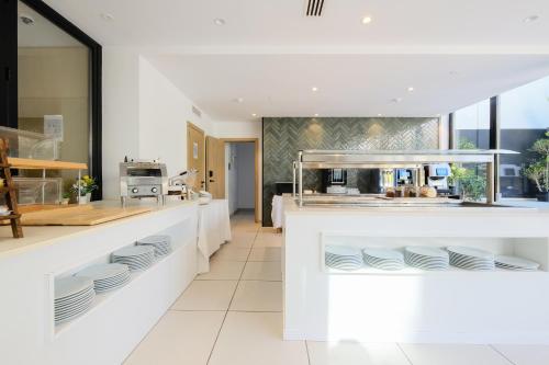 a kitchen with white counters and white plates on display at M. HOTEL in San Antonio