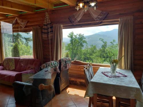 a dining room with a table and a large window at Vila Victoria in Pangarati