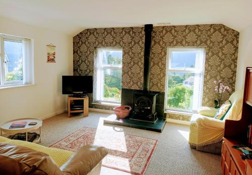 a living room with a couch and a fireplace at Catbells Sunrise Cottage Borrowdale Lake District in Keswick