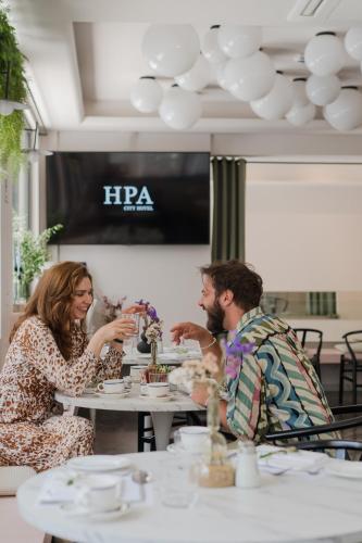 a man and woman sitting at a table in a restaurant at IRA - ΗΡΑ Hotel in Kalamata