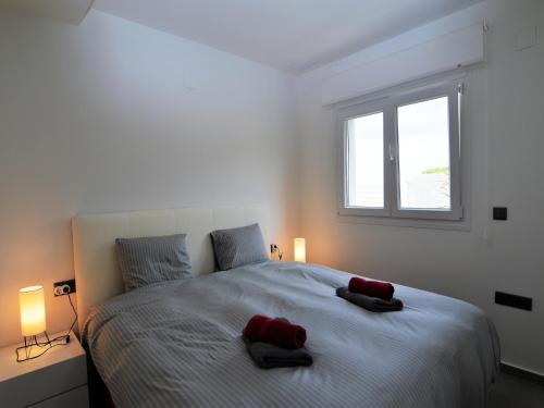 ein Schlafzimmer mit einem großen Bett mit zwei roten Kissen darauf in der Unterkunft Estancia Rojales con Jardín in Rojales