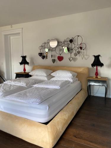 a bedroom with a large bed with chandeliers on the wall at Gulbės Apartamentai in Anykščiai